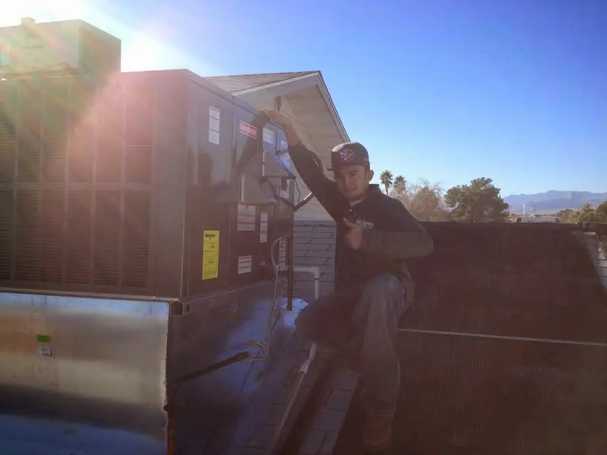 HVAC technician performing AC Tune-Up on a rooftop unit in White House